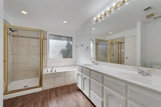 a bathroom with a double vanity sink a large mirror and shower