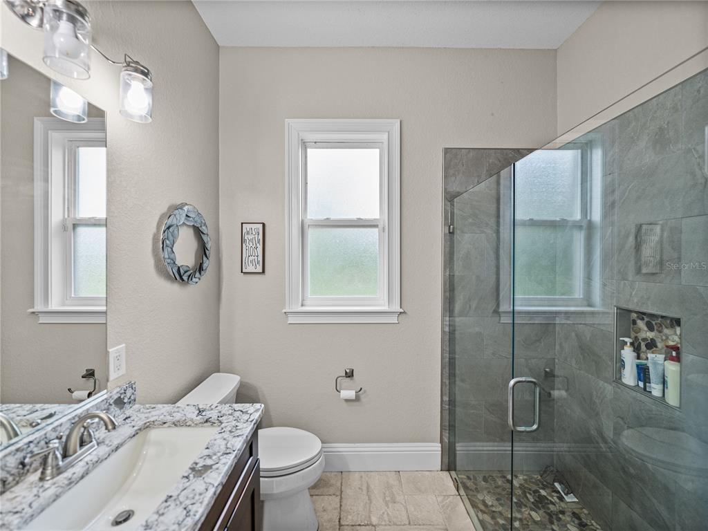 3985 Mammoth Grove Road Lake Wales, FL 33898 - Photo 53 of 97 a bathroom with a granite countertop sink a toilet and a mirror