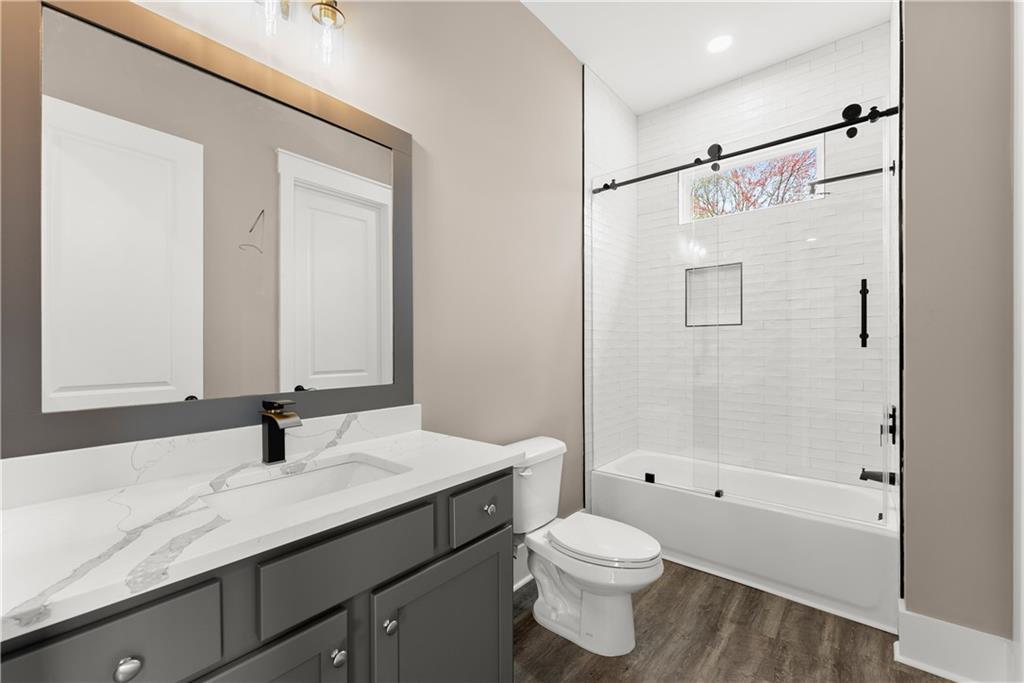 5697 Ball Ground Road Ball Ground, GA 30107 - Photo 36 of 63 a bathroom with a granite countertop sink a toilet and shower