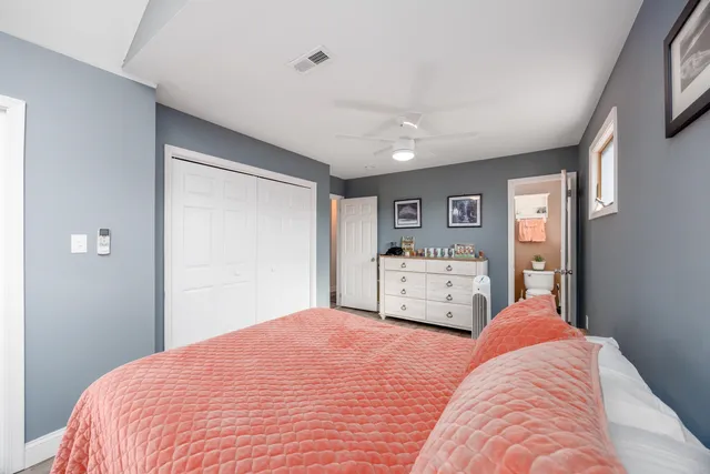 a bedroom with a bed and a large mirror