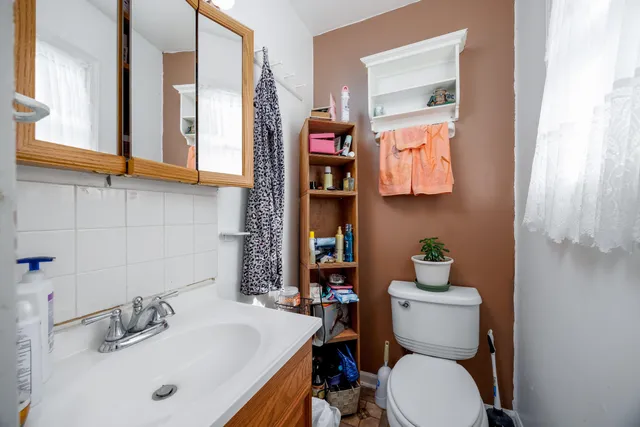 a bathroom with a toilet sink and mirror