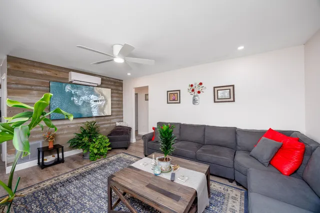 a living room with furniture plant and a window