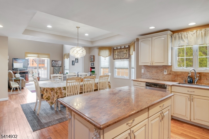 36 Harrison Street Nutley, NJ 07110 - Photo 14 of 36 a kitchen with a stove a sink a kitchen island with chairs and wooden floor