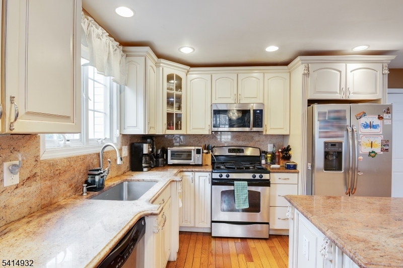 36 Harrison Street Nutley, NJ 07110 - Photo 16 of 36 a kitchen with kitchen island granite countertop a stove top oven a sink a counter space and cabinets