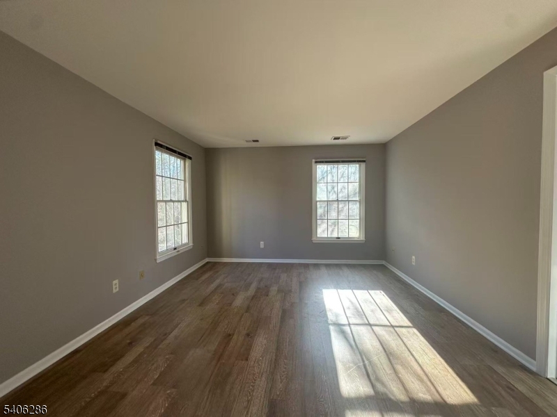 95 Jamestown Road, Unit 95 Bernards, NJ 07920 - Photo 10 of 17 an empty room with wooden floor and windows
