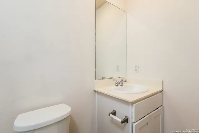 a bathroom with a sink a toilet and mirror