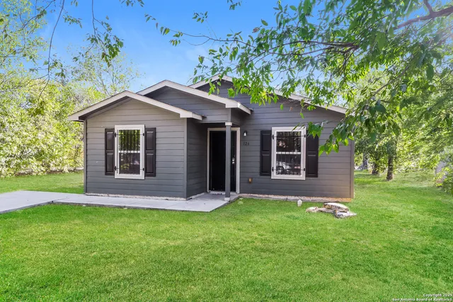 a front view of a house with a garden and yard