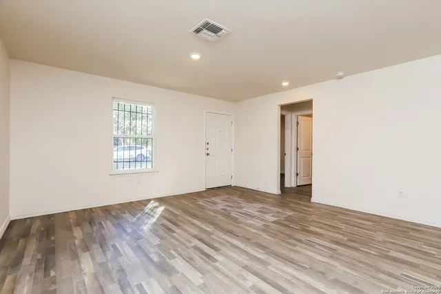 wooden floor in an empty room with a window