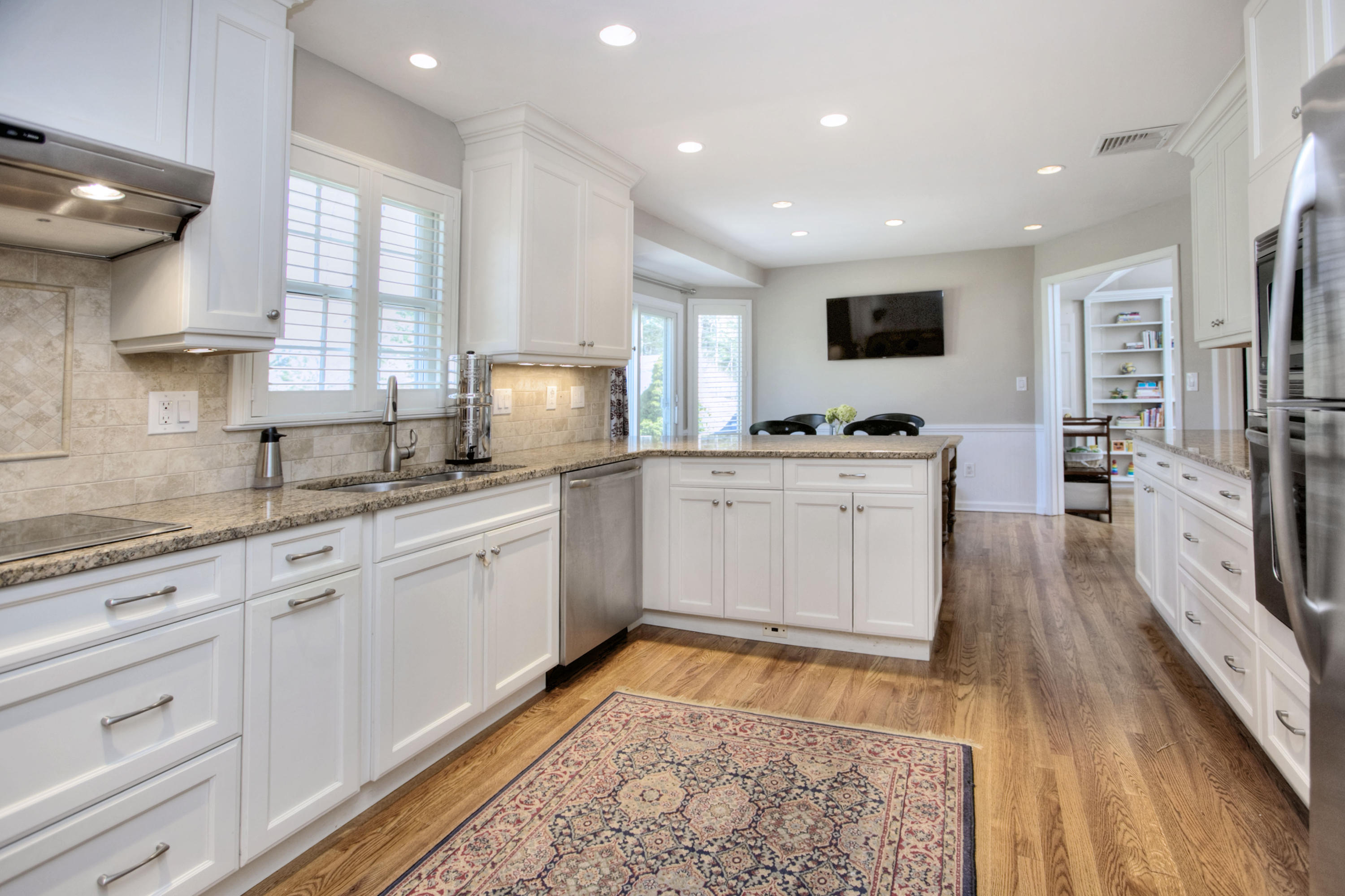 27 Summit Ridge Road New Canaan, CT 06840 - Photo 3 of 25 a large white kitchen with stainless steel appliances granite countertop a sink and dishwasher a stove with wooden floor