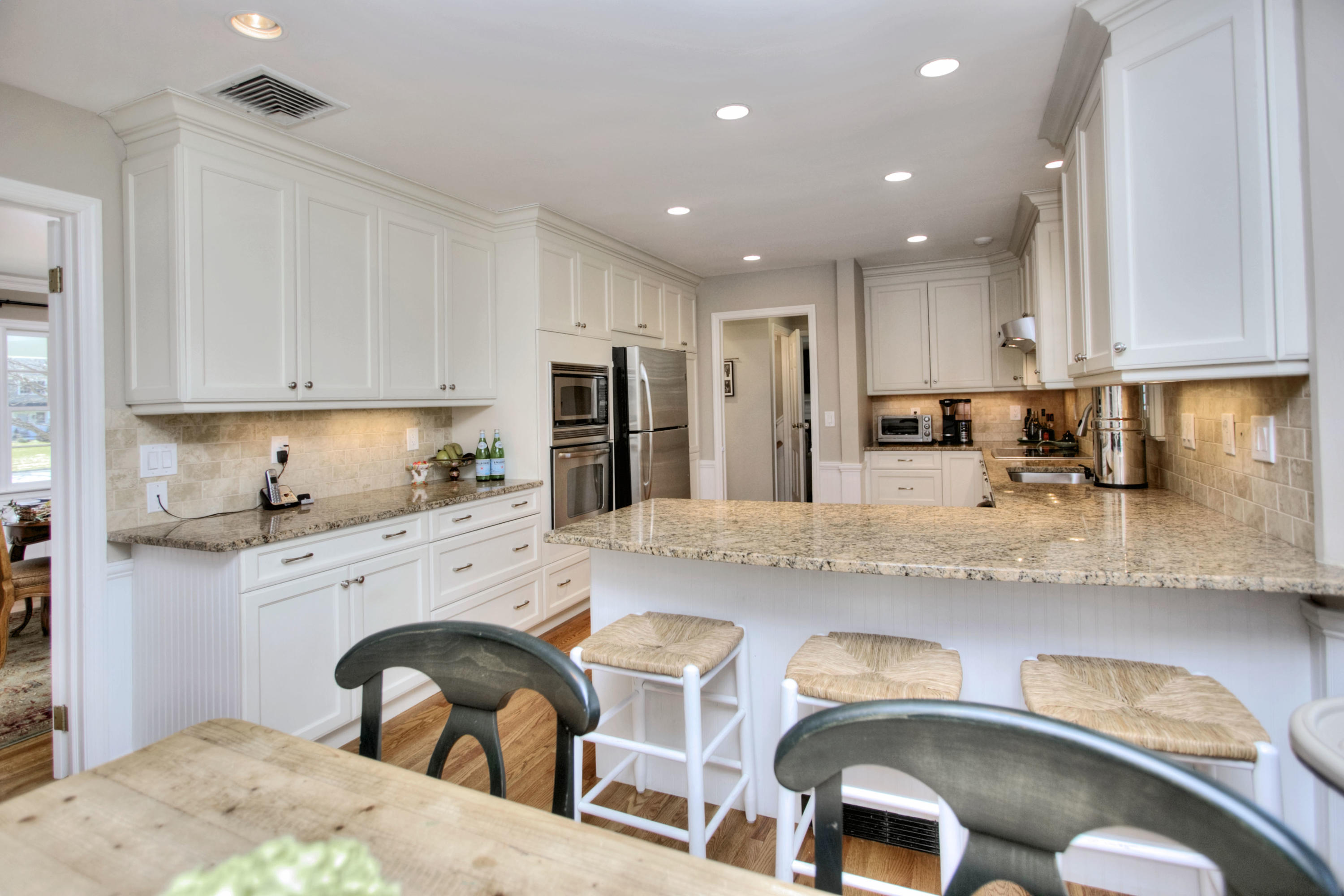 27 Summit Ridge Road New Canaan, CT 06840 - Photo 4 of 25 a kitchen with granite countertop white cabinets and stainless steel appliances