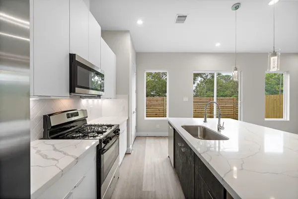 a kitchen with granite countertop a sink and a stove top oven