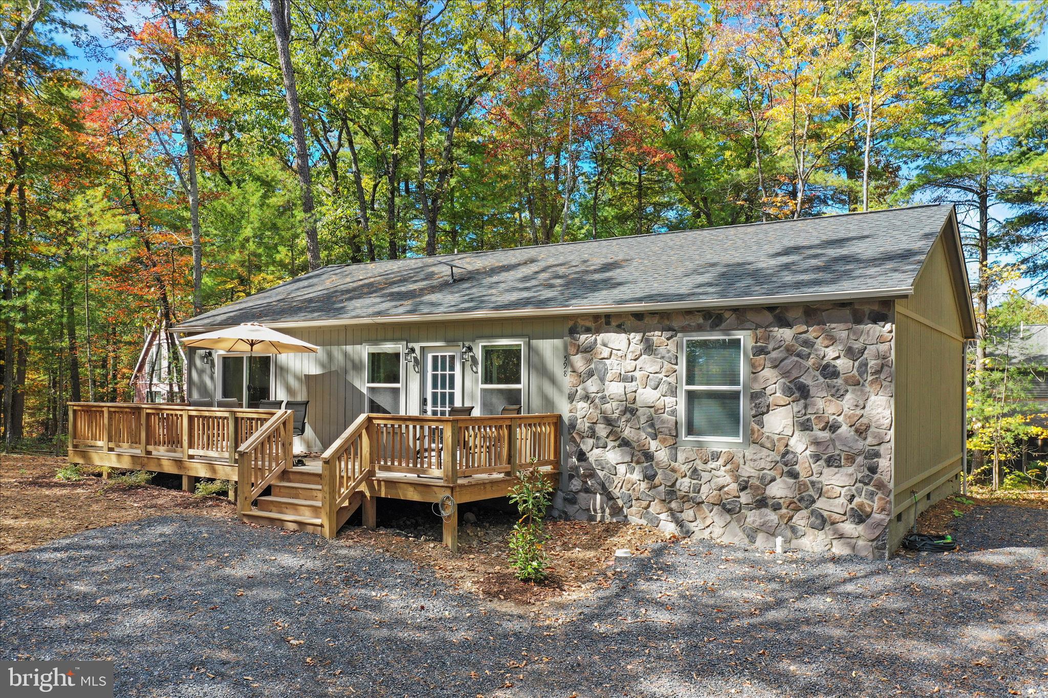 598 Crabapple Road Mount Jackson, VA 22842 - Photo 2 of 32 a view of a wooden house with a large window and lawn chairs