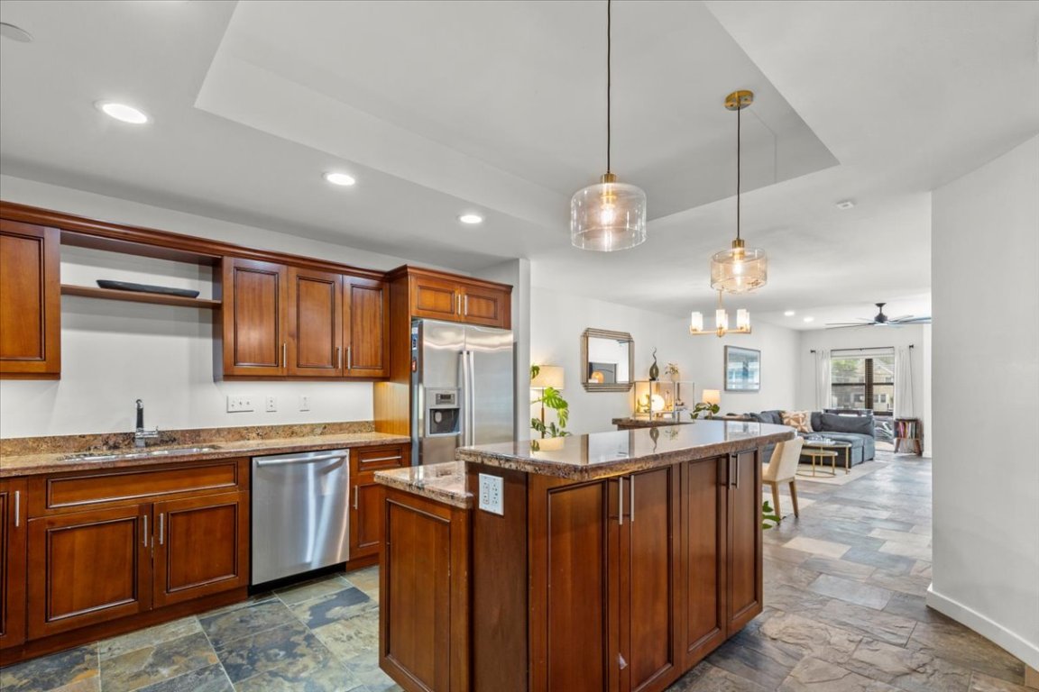 1812 West Avenue, Unit 306 Austin, TX 78701 - Photo 13 of 38 Kitchen featuring stone finish floor, a sink, stainless steel appliances, a tray ceiling, and recessed lighting