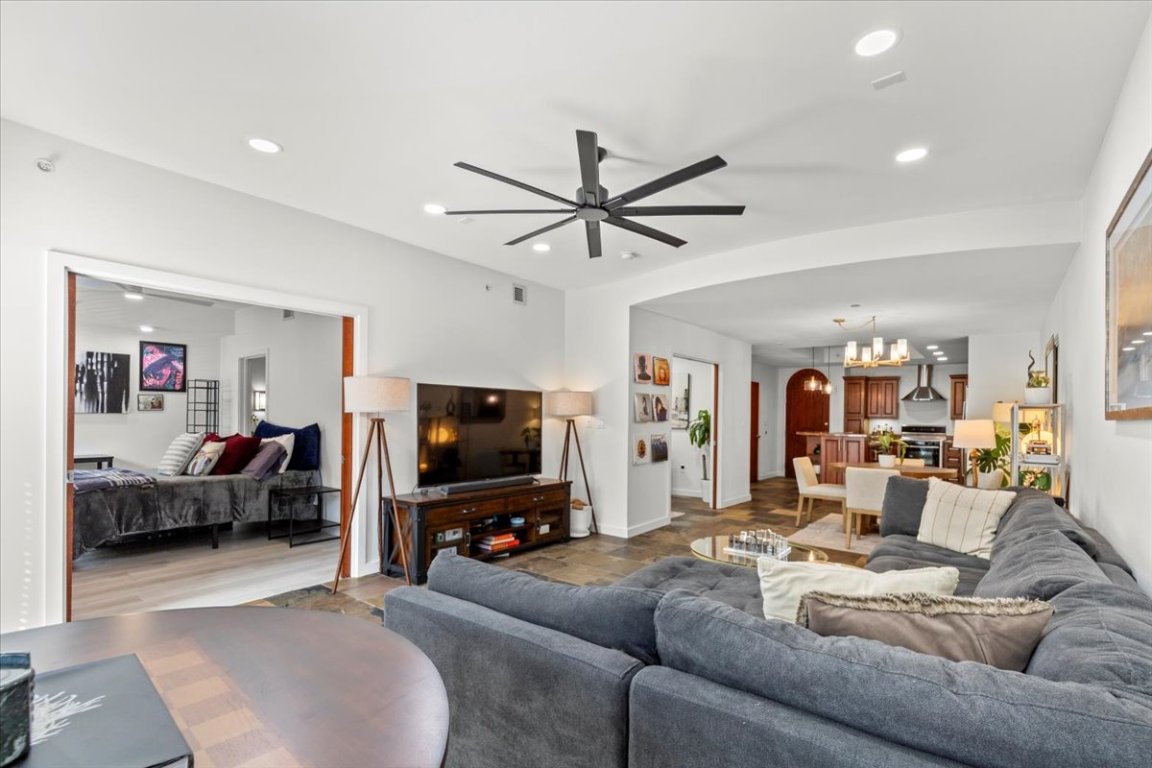 1812 West Avenue, Unit 306 Austin, TX 78701 - Photo 24 of 38 Living room featuring recessed lighting, visible vents, baseboards, and ceiling fan with notable chandelier
