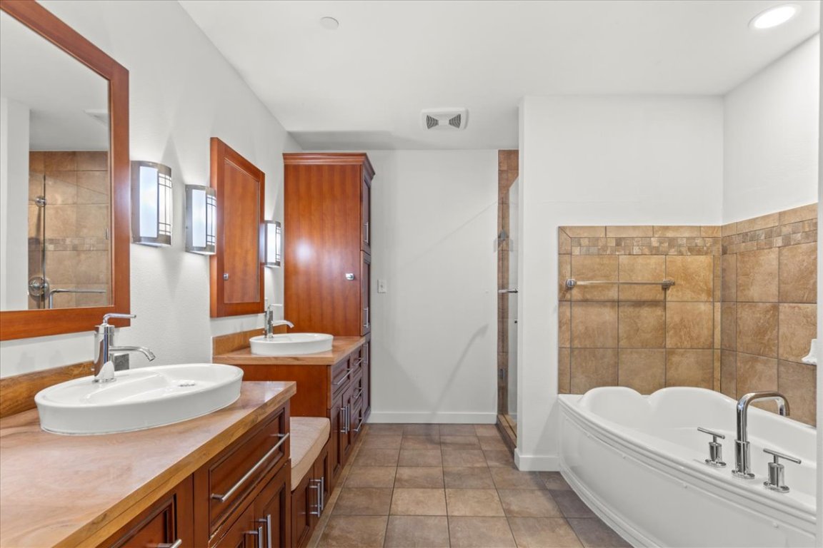 1812 West Avenue, Unit 306 Austin, TX 78701 - Photo 29 of 38 Bathroom featuring visible vents, a stall shower, a garden tub, and a sink