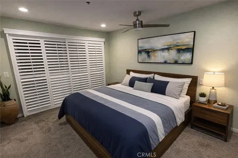 a bedroom with a bed a flat screen tv and a couch
