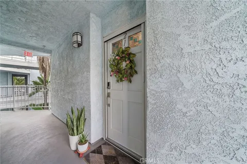 a view of a hallway with wooden floor and a potted plant