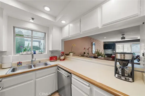 a kitchen with granite countertop a refrigerator stove and sink