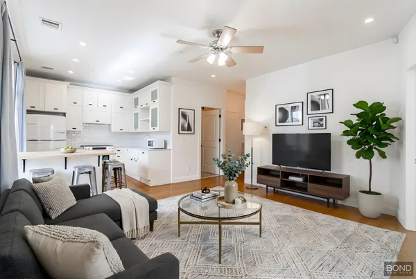 a living room with furniture a chandelier and a flat screen tv