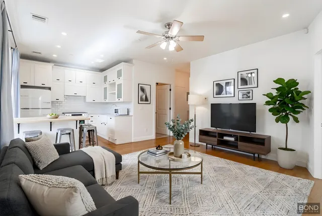 a living room with furniture a chandelier and a flat screen tv