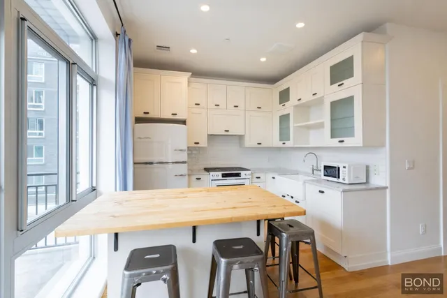 a kitchen with stainless steel appliances a table chairs and wooden floor