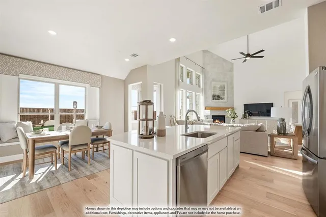 a large kitchen with a counter top space a sink stainless steel appliances and cabinets