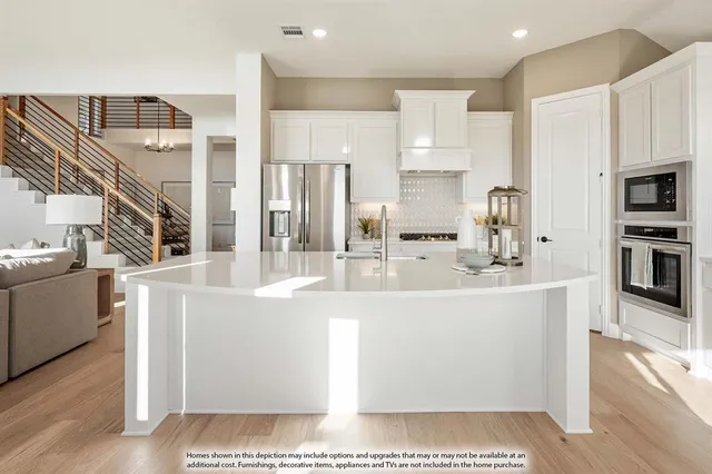 a large white kitchen with stainless steel appliances