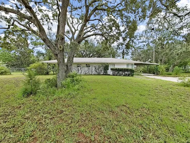 a view of house with a yard