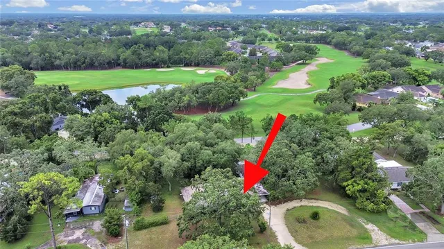 an aerial view of a house with a yard and lake view