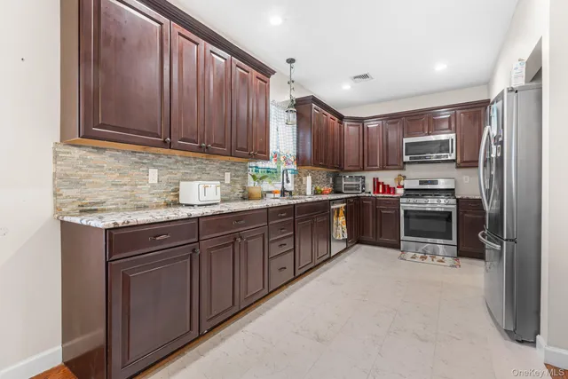 a kitchen with stainless steel appliances granite countertop a refrigerator and a sink