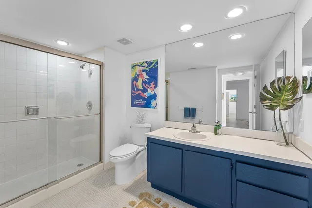 a bathroom with a double vanity sink toilet and shower