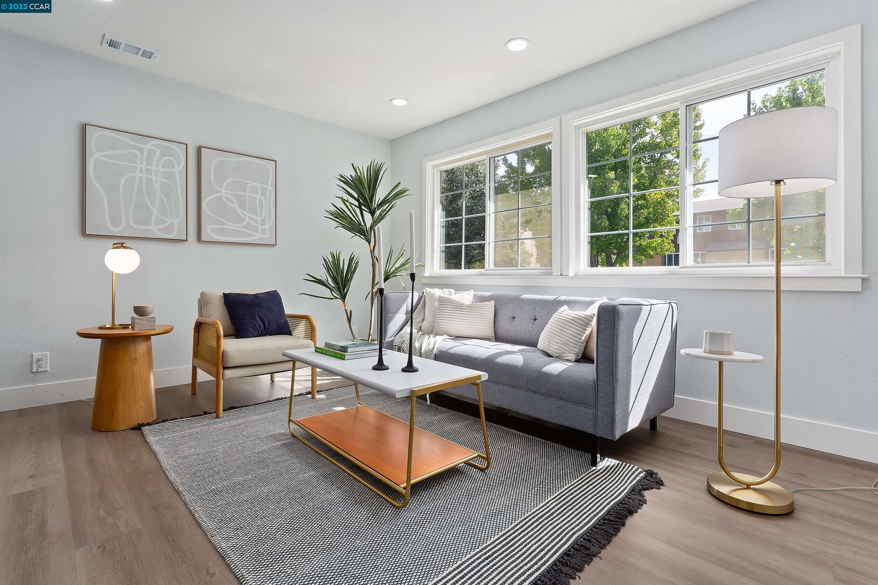 a living room with furniture wooden floor and a lamp