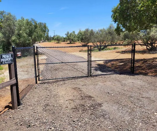 a view of a yard with wooden fence