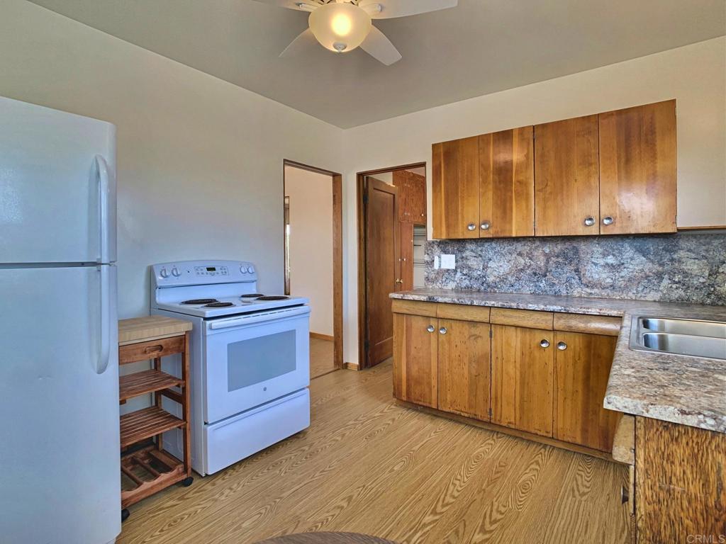 616 Alpine Heights Road Alpine, CA 91901 - Photo 11 of 50 a kitchen with stainless steel appliances granite countertop a stove a sink dishwasher and a refrigerator with wooden floor