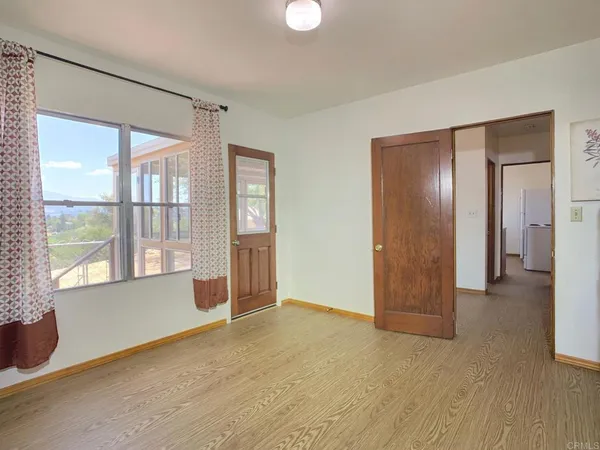 a view of an empty room with glass door and a window