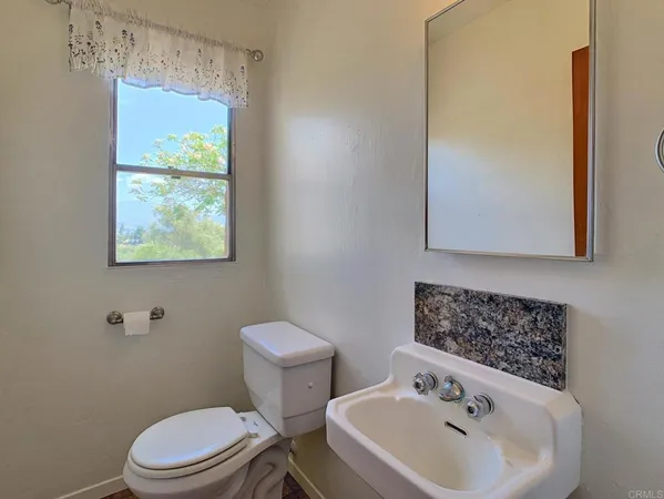 a bathroom with a sink mirror and toilet