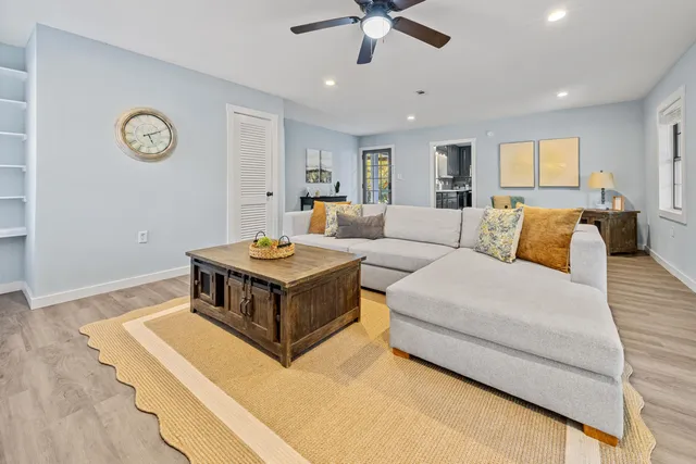 a living room with furniture and a wooden floor