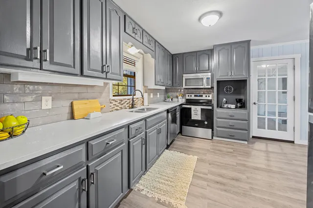 a kitchen with stainless steel appliances granite countertop a sink counter space cabinets and a stove