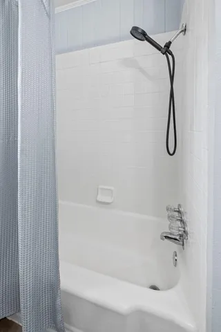a bathroom with a bath tub with a shower