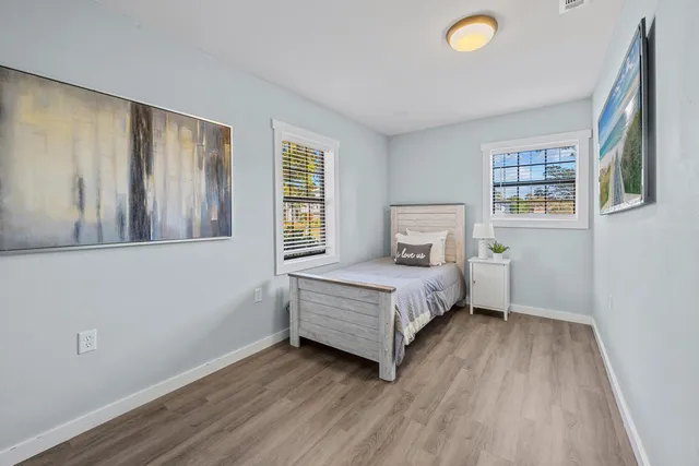 a bedroom with a bed and wooden floor