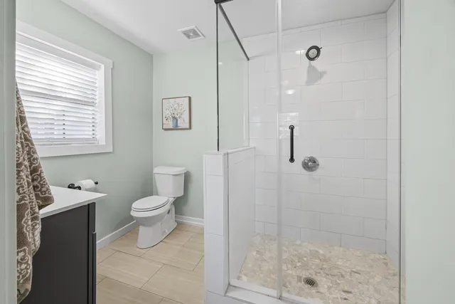 a bathroom with a toilet and a shower