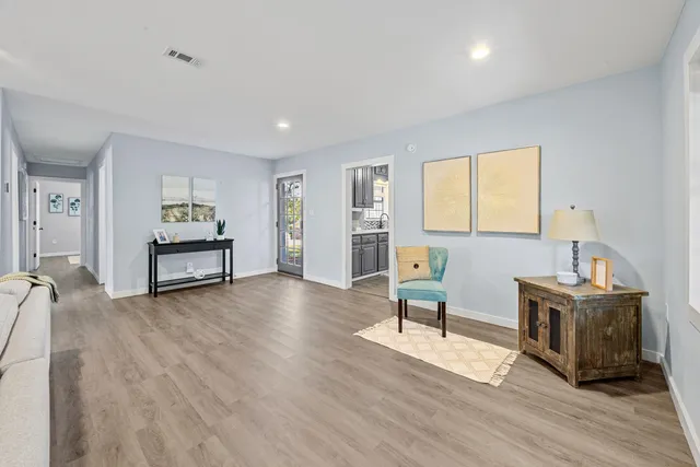 a living room with furniture and a wooden floor