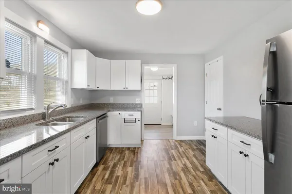a kitchen with granite countertop a sink stove and refrigerator