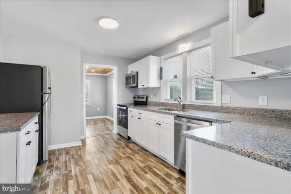 a kitchen with granite countertop a sink stove and refrigerator