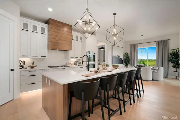 a kitchen with stainless steel appliances kitchen island granite countertop a sink a stove a dining table and chairs
