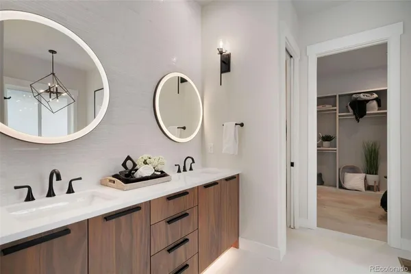 a en suite bathroom with a double vanity sink and a mirror