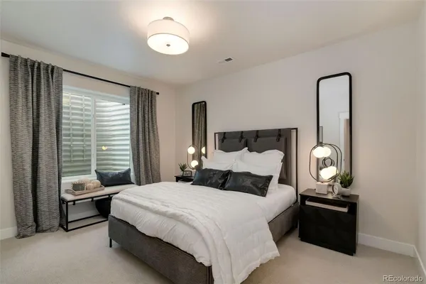 a bedroom with a bed and painting on the wall