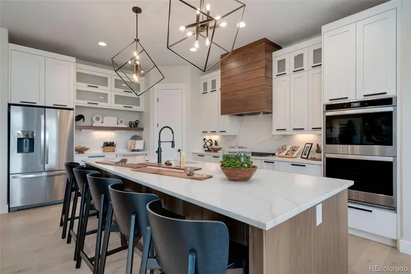 a kitchen with stainless steel appliances granite countertop a sink a stove and a refrigerator