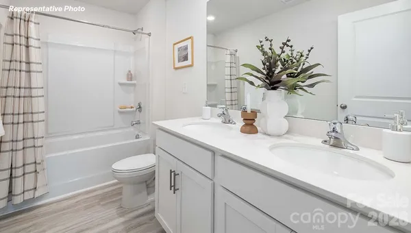 a bathroom with a granite countertop sink toilet a large mirror a bathtub and shower