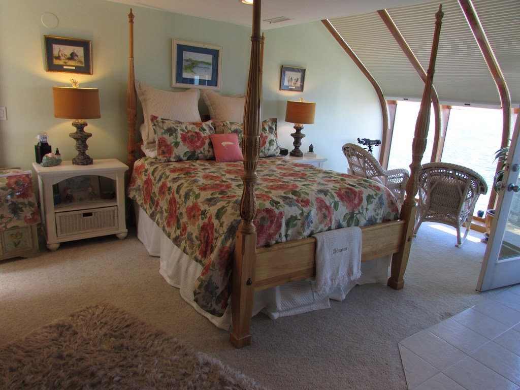 59 Oceanside Drive, Unit 59 Hull, MA 02045 - Photo 15 of 29 a large bed sitting in a bedroom next to a window